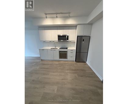 A kitchen with white cabinets and a wooden floor.