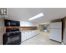 A kitchen with white cabinets and a black stove top oven.