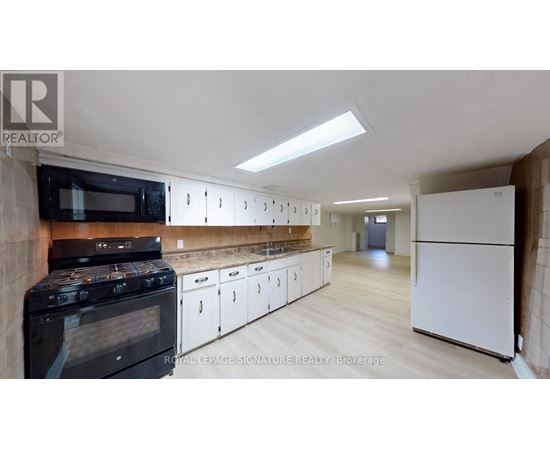 A kitchen with white cabinets and a black stove top oven.