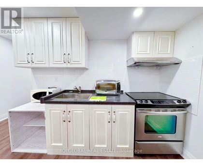 A kitchen with white cabinets and a black countertop.