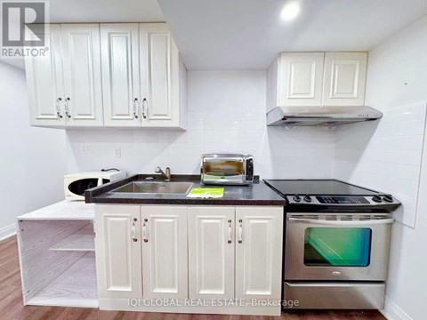 A kitchen with white cabinets and a black countertop.
