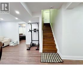 A room with a staircase and a gym equipment.