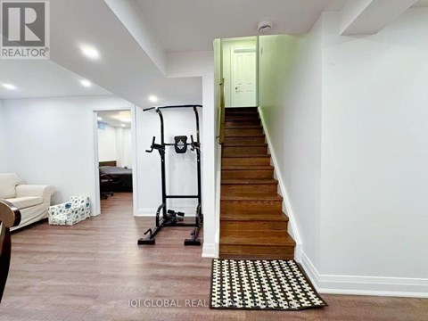 A room with a staircase and a gym equipment.