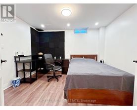 A bedroom with a bed, desk, and chair.