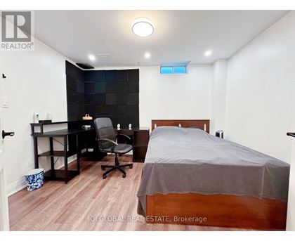 A bedroom with a bed, desk, and chair.