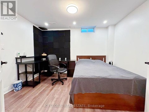 A bedroom with a bed, desk, and chair.