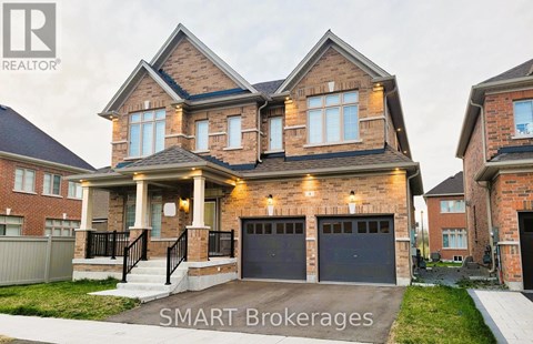 A large, two-story house with a brick facade and a garage is for sale.