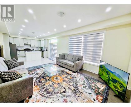 A living room with a grey sofa and a rug with a floral pattern.