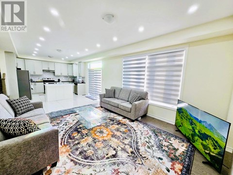 A living room with a grey sofa and a rug with a floral pattern.