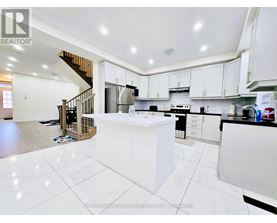 A modern kitchen with white cabinets and a central island.