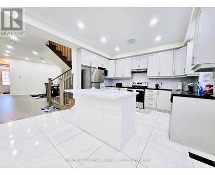 A modern kitchen with white cabinets and a central island.