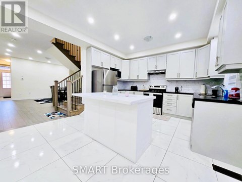 A modern kitchen with white cabinets and a central island.