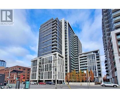 A modern glass building stands tall in an urban setting.