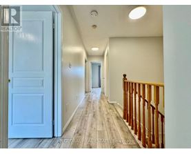 A hallway with a white door and a wooden railing.