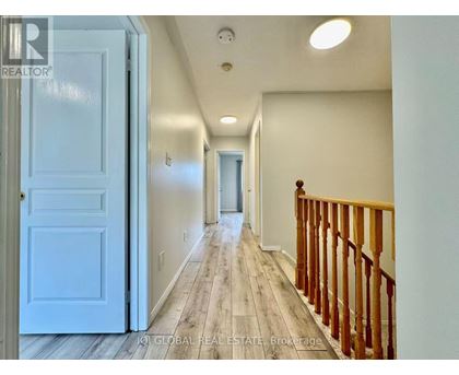 A hallway with a white door and a wooden railing.