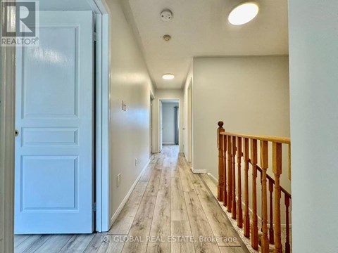 A hallway with a white door and a wooden railing.