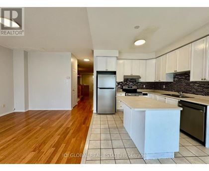 A kitchen with white cabinets and a wooden floor.