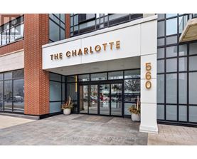 The Charlotte building is a modern structure with a glass facade and a brick column.