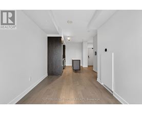 A spacious room with a wooden floor and white walls.