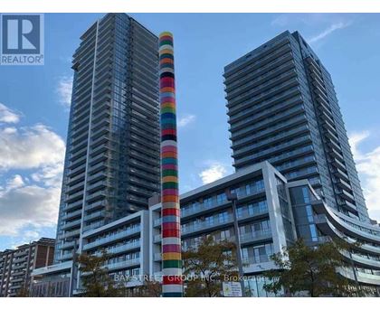 Two tall buildings with a colorful tower in the middle.