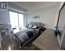 A bedroom with a large bed and a wooden floor.