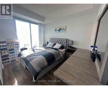 A bedroom with a large bed and a wooden floor.