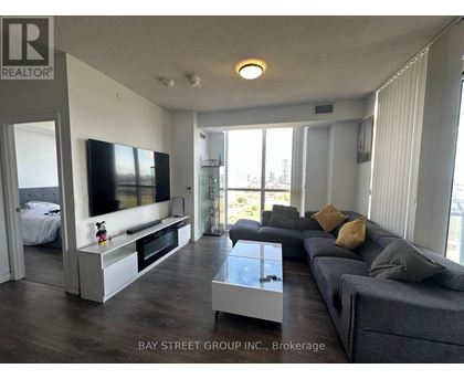 A living room with a grey couch and a television.