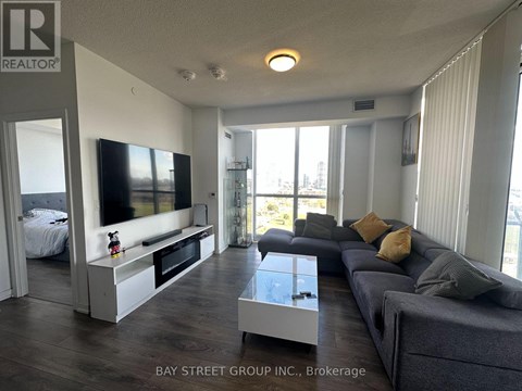 A living room with a grey couch and a television.
