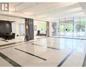 A spacious lobby with a black and white floor and a glass wall.