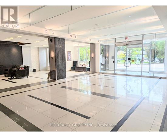 A spacious lobby with a black and white floor and a glass wall.