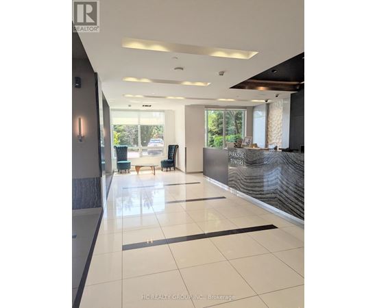 A hallway with a reception desk and a window in the background.