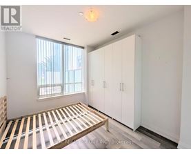 A bedroom with a bed, a window, and a wardrobe.