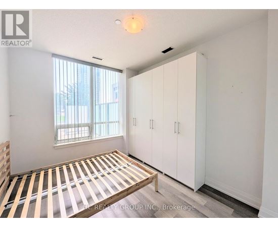 A bedroom with a bed, a window, and a wardrobe.