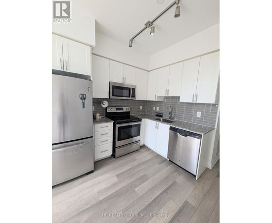 A kitchen with white cabinets and a stainless steel refrigerator.