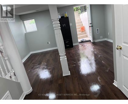 A room with wooden floors and a black cabinet.