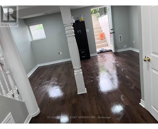 A room with wooden floors and a black cabinet.