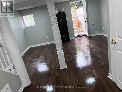 A room with wooden floors and a black cabinet.