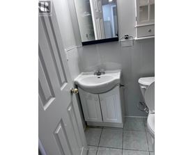 A white bathroom with a sink and toilet.