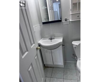 A white bathroom with a sink and toilet.