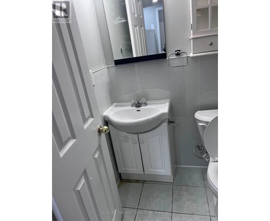 A white bathroom with a sink and toilet.
