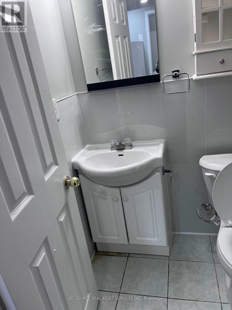 A white bathroom with a sink and toilet.