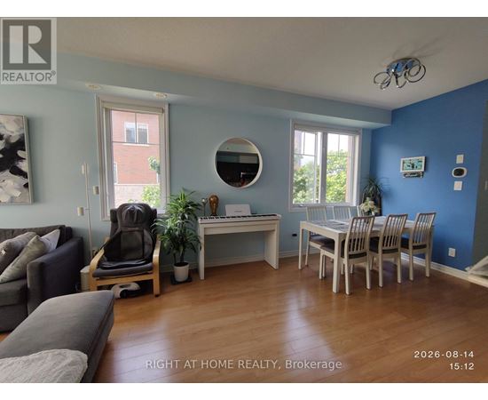 A living room with a grey couch and a white desk with a chair.
