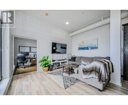 A living room with a grey couch and a wooden floor.