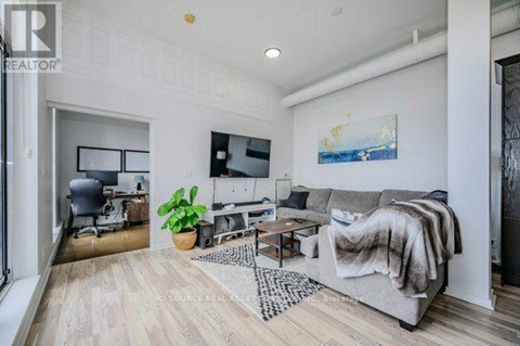A living room with a grey couch and a wooden floor.
