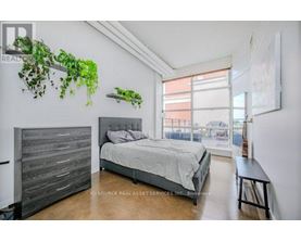 A bedroom with a large bed and a wooden headboard.