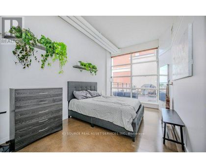 A bedroom with a large bed and a wooden headboard.