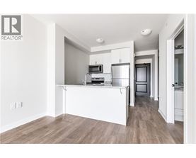 A white kitchen with wood flooring and a white island.