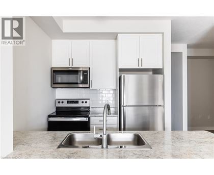 A modern kitchen with a stainless steel refrigerator and microwave above the sink.