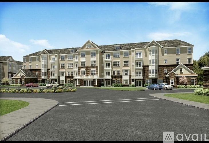A large apartment complex with a parking lot in front.