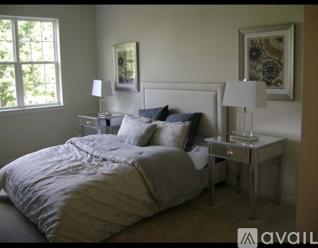 A bedroom with a large bed and two nightstands with lamps.